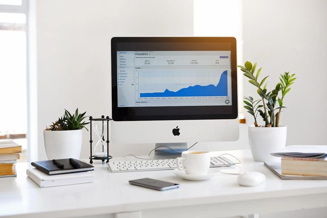 A desk with a computer showing the analytics of an online business