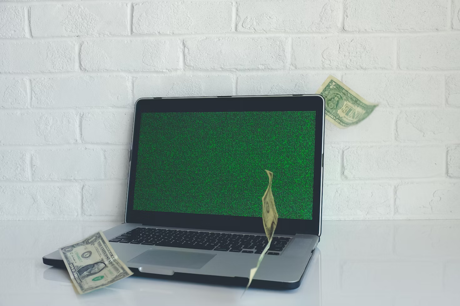 US dollar bills surrounding a laptop