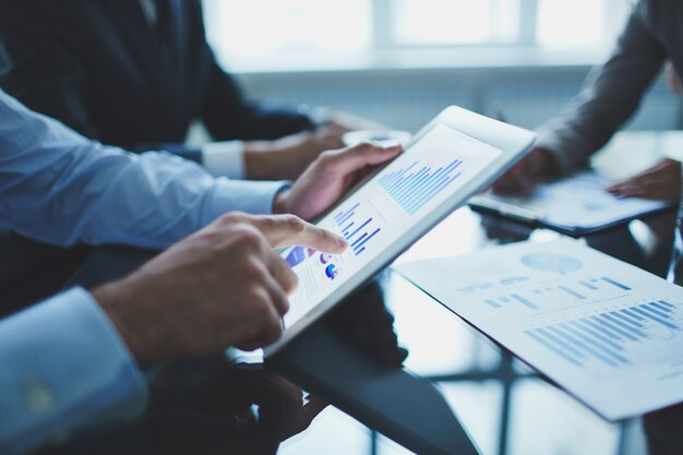 A person examining financial graphs on a tablet, representing the thorough analysis.