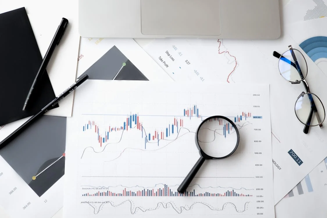 A magnifying glass placed on a paper with graphs