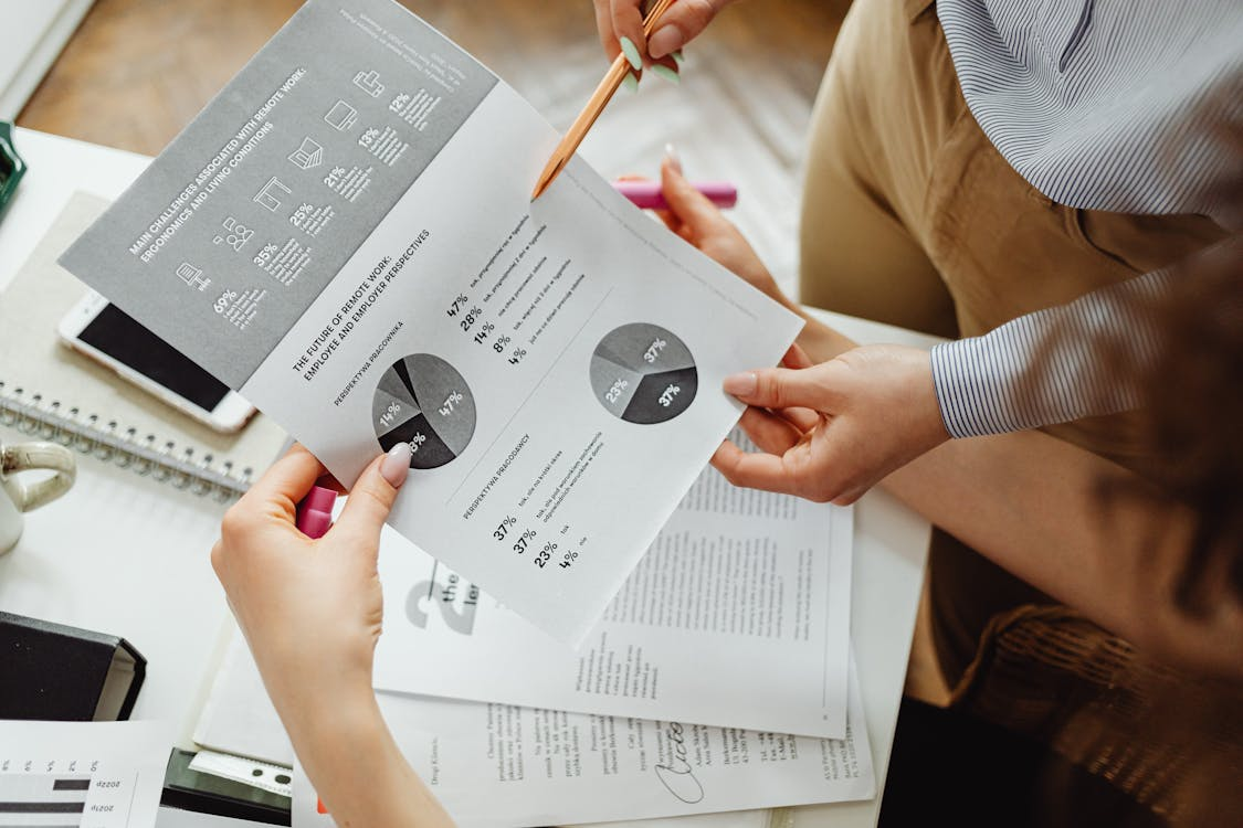 Two people checking graphs on a paper