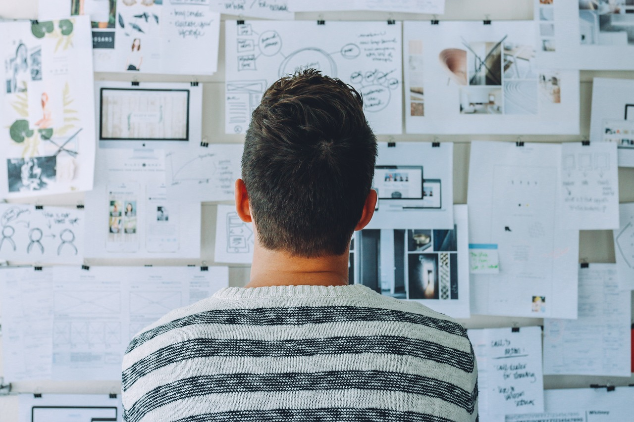A person looking at the wall with papers