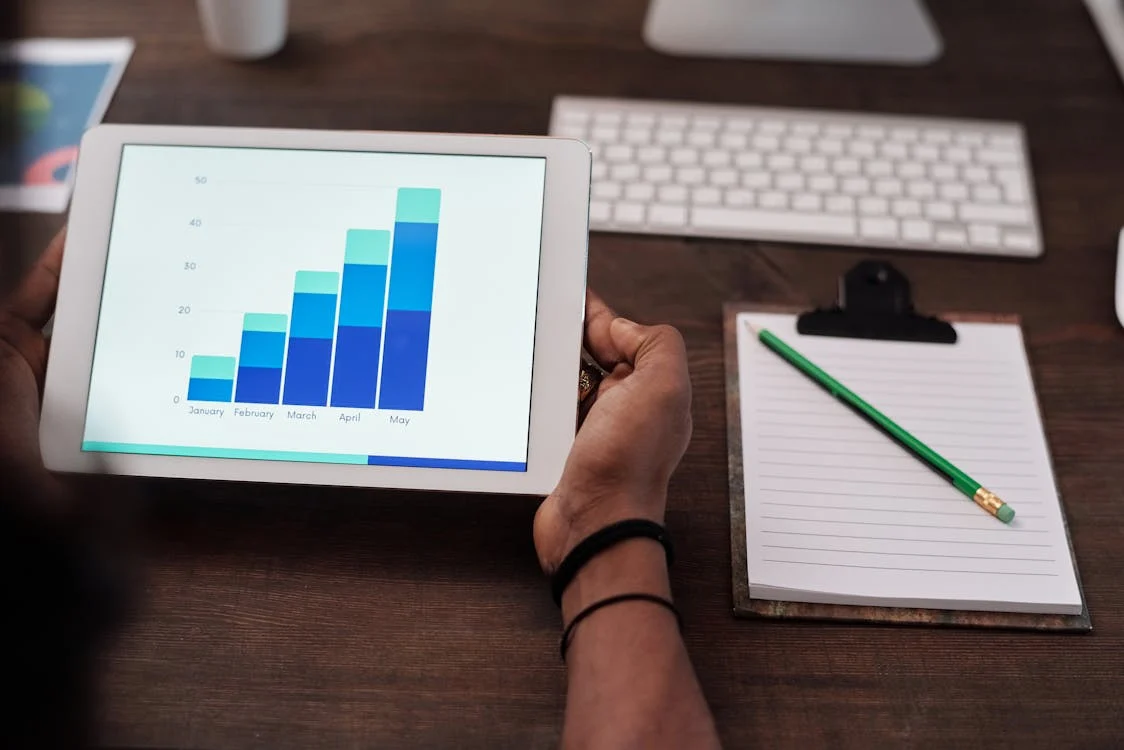 A person holding a tablet with graphs
