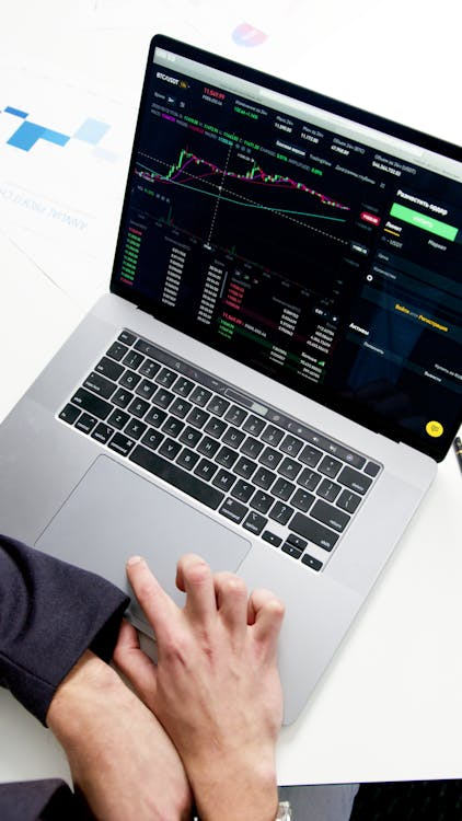 an individual navigating assets and financial data on their laptop